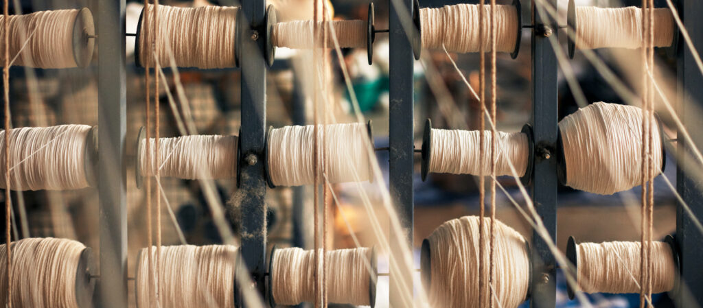 Photograph of reels of beige coloured natural fibres